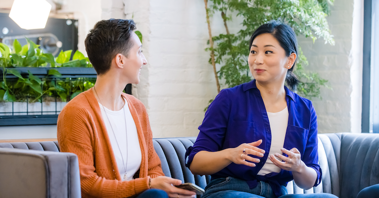 Two Capital One associates involved in empowher sit on a couch and talk