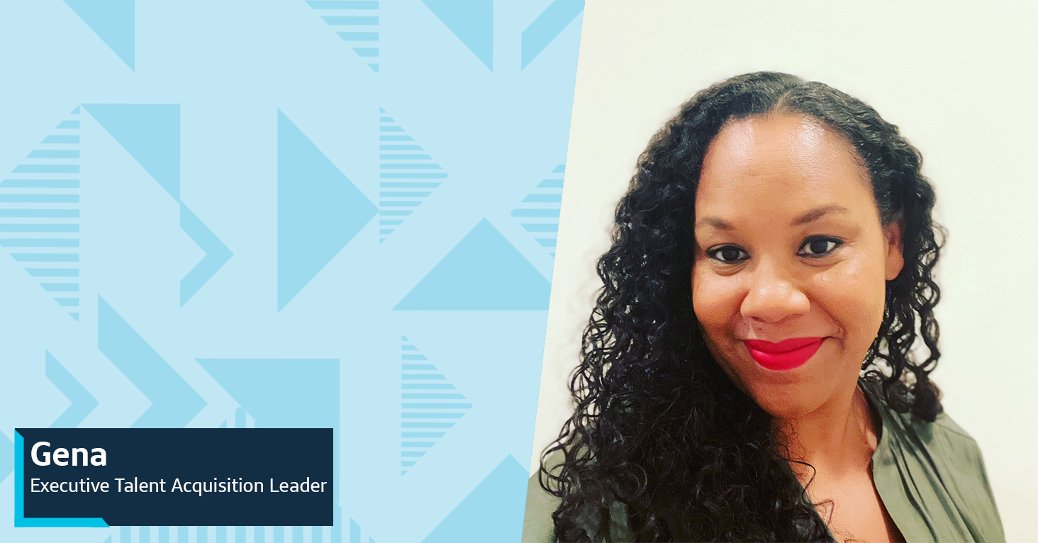 Gena, Executive Talent Acquisition Leader at Capital One, smiles at the camera standing in front of a white wall, all next to a two-tone blue triangular background to the left