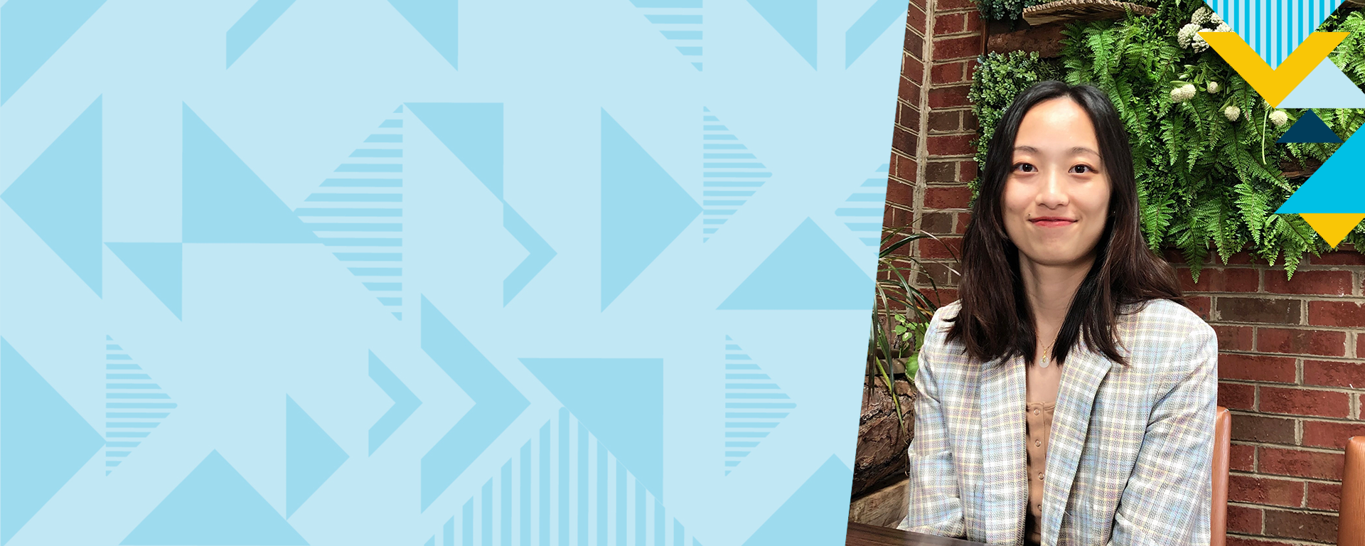 Capital One associate Ruikang stands in front of a brick wall smiling