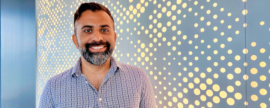 Capital One associate Samir stands in front of a lit up dotted wall